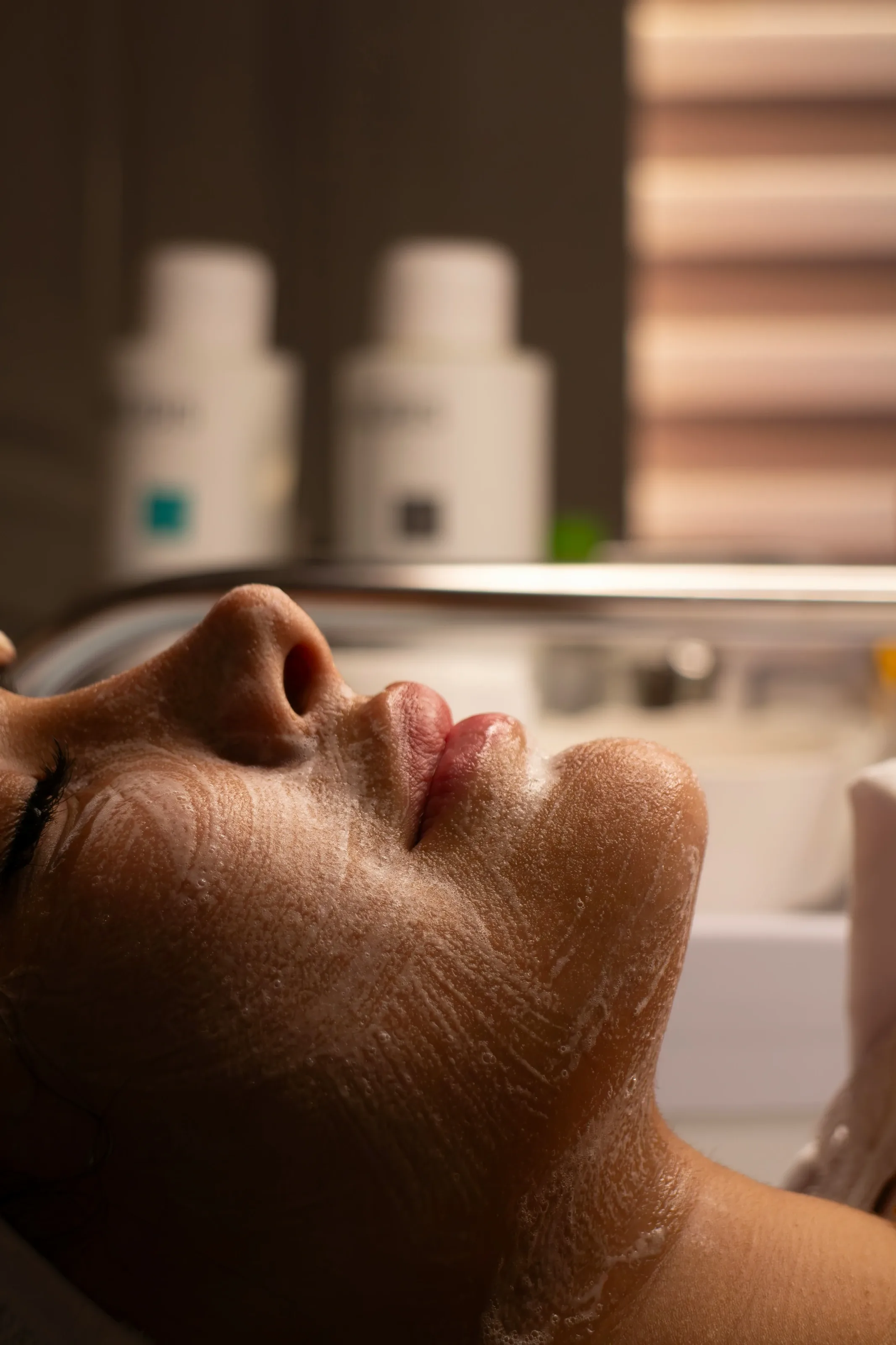 Client relaxing during a facial with a treatment mask applied