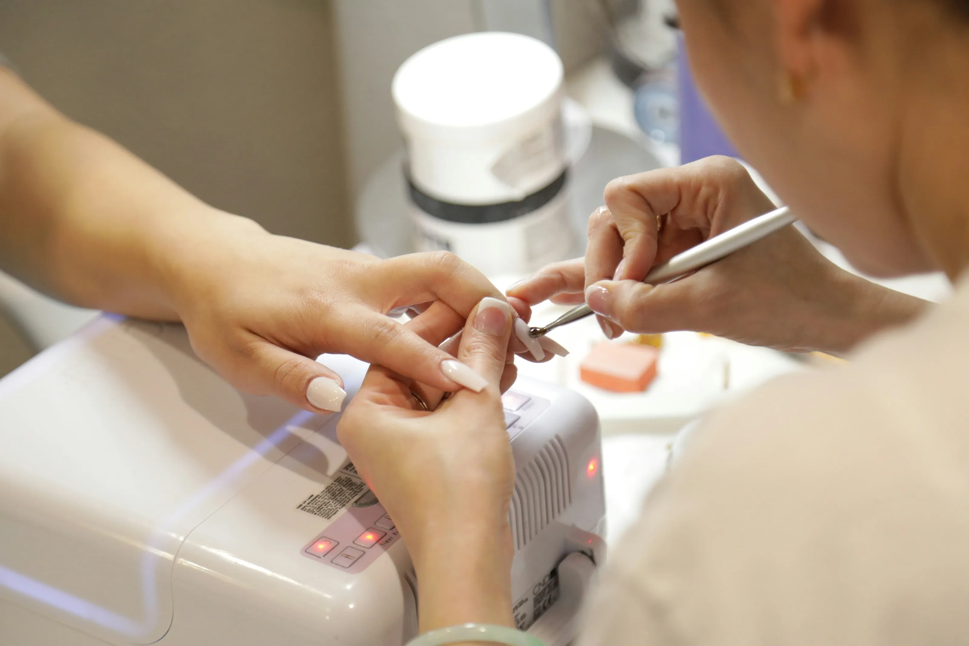 Nail technician shaping a client's nails during a manicure