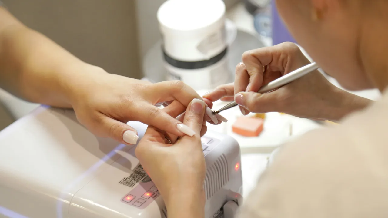 Nail technician shaping a client's nails during a manicure