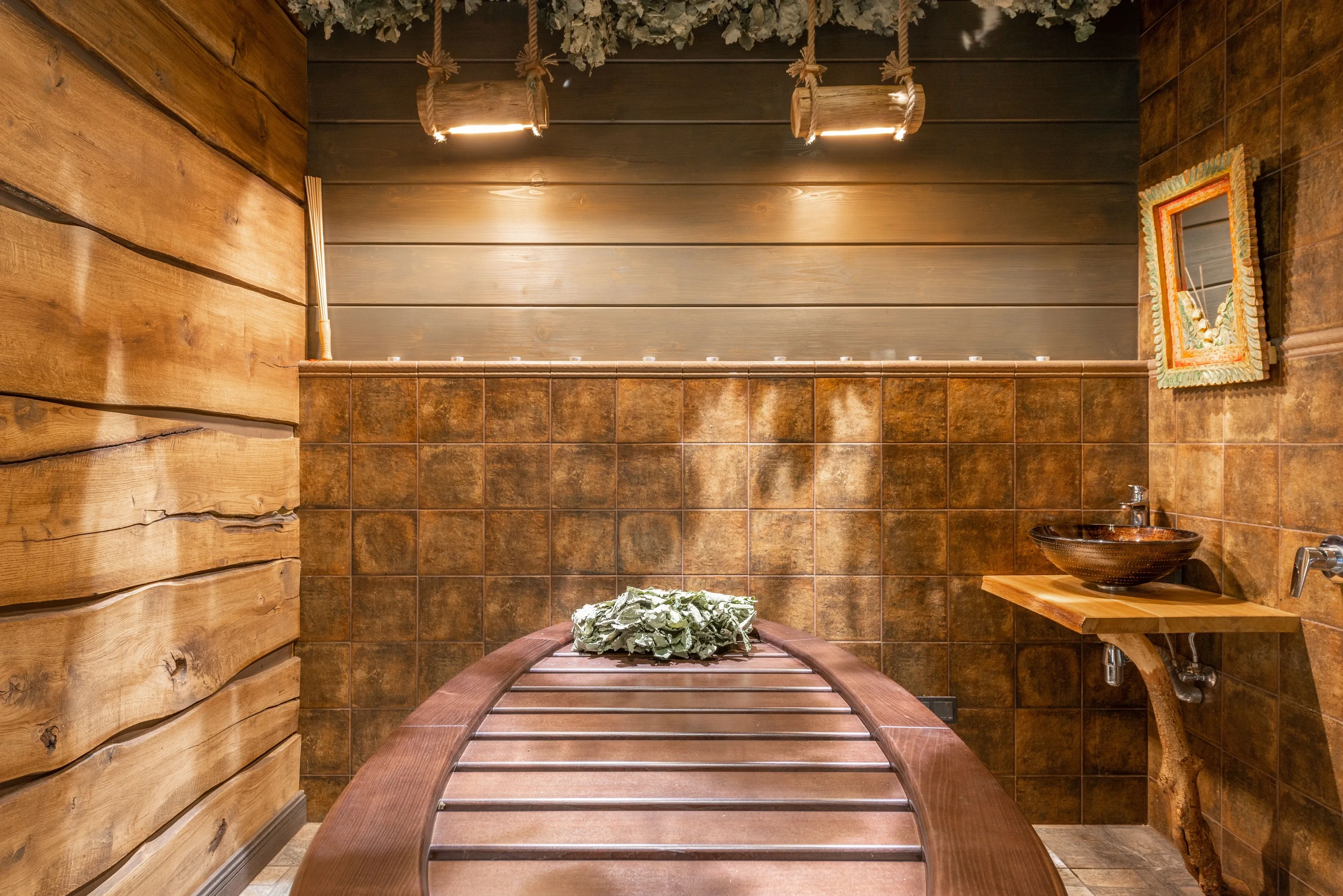 Warm wooden spa room with a treatment couch and pendant lights